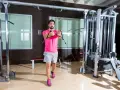 Man tränar bröstmusklerna med cable flyes i ett modernt gym.