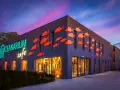 Oceanarium w Międzyzdrojach, z neonowym napisem i pomarańczowymi rybkami na fasadzie, to świetne miejsce na rodzinne atrakcje dla dzieci.