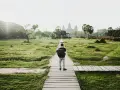 Chłopiec z plecakiem idzie ścieżką do Angkor Wat, jednego z cudów największego kontynentu na ziemi.