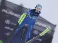 Skoczkini narciarska w locie, w niebieskim kombinezonie, z nartami Fischer. Planica.