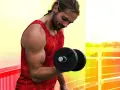 Homme musclé faisant un exercice pour muscler les bras avec un haltère.