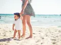 Mama i dziecko na plaży, idealne miejsce, by zapytać, gdzie lecieć w kwietniu. Słońce, piasek i morze.