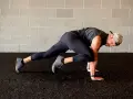 Un homme fait des mountain climbers pour son renforcement musculaire à la maison.