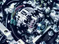 Detailaufnahme einer Lichtmaschine im Auto, mit Kabeln und Riemen.