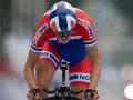 Oskar Svendsen, a cyclist in a red and blue Norwegian kit, races intensely, focused on the finish line.