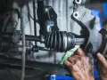 Mechanik wymienia przegub w samochodzie. Dowiedz się, ile kosztuje wymiana przegubu i jakie są objawy jego zużycia.