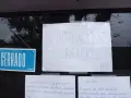 Cartel de "CERRADO" y otro escrito "TEMPORALMENTE CERRADOS" en la ventana de un bar restaurante.