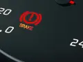 The car's dashboard shows the red brake light on, indicating a potential issue.