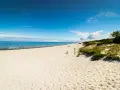 Piękna, piaszczysta plaża na Mierzei Wiślanej. Błękitne niebo i spokojne morze zapraszają do wypoczynku.