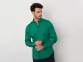 Uomo con camicia verde brillante, un perfetto abbinamento camicia verde uomo per un look moderno.