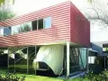 Villa Dall'Ava, une maison moderne aux lignes épurées, avec un étage supérieur rouge à rayures blanches, suspendu au-dessus d'un rez-de-chaussée vitré.