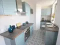 Cocina moderna y luminosa con armarios celestes y suelo hidráulico. Una opción económica para renovar cocina con poco dinero.