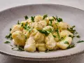 Pyszne gnocchi z kremowym sosem, posypane świeżą natką pietruszki. Idealne danie dla każdego miłośnika włoskiej kuchni.