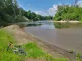 Rower leży na trawie nad rzeką, otoczoną zielenią. To malowniczy zakątek, prawdziwa szwajcaria podlaska.