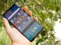 En hand håller en Samsung Galaxy Note 9 med många appar på skärmen, bland annat BankID och Spotify.
