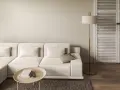 Divano modulare color tortora, tavolino ovale con libri, lampada da terra dorata e porta a soffietto in legno.