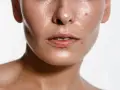 Primo piano del viso lucido, con pori visibili e qualche imperfezione. Scopri come eliminare il sebo in eccesso dal viso per una pelle radiosa.
