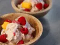 Två skålar med krämig proteinglass, toppad med hallon och mangobitar. Ett perfekt recept för en hälsosam dessert.