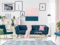 Granatowa sofa i fotele z pudrowym różem tworzą elegancką przestrzeń.