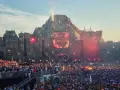 Tłum ludzi na największym festiwalu muzycznym na świecie, z wulkaniczną sceną i pokazem sztucznych ogni.