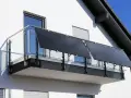 Nowoczesna fotowoltaika na tarasie. Panele słoneczne zamontowane na balustradzie, czerpiące energię ze słońca.