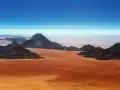 Pustynny krajobraz w **Afryce, Namibia**. Czerwona ziemia i skaliste góry pod błękitnym niebem.