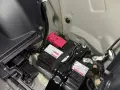 Akumulator 12V w Toyocie Prius znajduje się w bagażniku, pod plastikową osłoną. Widoczne są dwa akumulatory, jeden z czerwonym zabezpieczeniem.