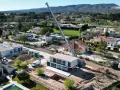 Construcción moderna en zona residencial, mostrando la diferencia entre urbano y urbanizable con grúa y excavadora.