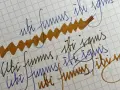 Papel cuadriculado con escritura a mano en tinta azul y marrón. Se lee "ubi fumus, ibi ignis" repetidamente.