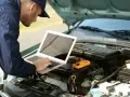 Mechanik diagnozuje usterkę w Oplu p2279, używając laptopa i multimetru.