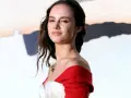 Martyna Byczkowska w białym gorsie i czerwonym szalu, z wiatrem we włosach.