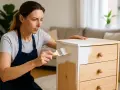 Donna dipinge un mobile in legno con una mano di cementite senza carteggiare, trasformando il mobile con facilità.