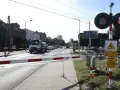 Przejazd kolejowy z zaporami i czerwonymi światłami. Samochód ciężarowy czeka na przejazd.