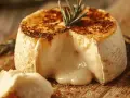 Camembert coulant, doré et gratiné, tout juste sorti de l'air fryer. Un délice crémeux à déguster avec une branche de romarin.