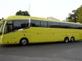 Żółty autokar firmy ANICK stoi na ulicy. Trudno określić, ile miejsc ma autokar, ale wygląda na bardzo pojemny.