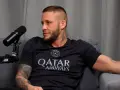 Paweł, znany jako Scarface, z tatuażem "BOMBA" na ramieniu, siedzi przy mikrofonie.