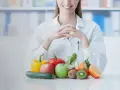 Dietetyk z uśmiechem prezentuje świeże warzywa i owoce. Dowiedz się, czy po gastroskopii można jeść zdrowo i bezpiecznie.