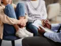Un professionnel note des informations sur un jeune en difficulté, peut-être pour savoir comment faire une information préoccupante.