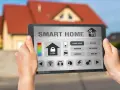 Tablet mit App zur Steuerung des smart home einrichten. Anzeige von Temperatur, Schloss, Licht und Räumen wie Wohnzimmer.