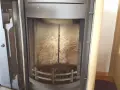 Innenraum eines Ofens mit einem vertikalen Riss im schamottstein gebrochen. Asche und Ruß bedecken den Boden und die Wände.