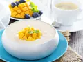 Pyszny deser z mango, jagodami i kawą. Ten mango smak to idealny początek dnia.