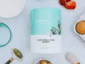 Un pot de pur collagène marin neutre, entouré d'ingrédients pour un soin complet : œufs, fraises, poudre blanche, et un rouleau de jade.