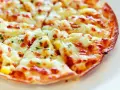Pyszna, gorąca pizza z patelni, z ciągnącym się serem i ziołami, gotowa do podania.
