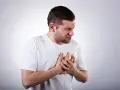 Mężczyzna z bólem w klatce piersiowej, który może być jednym z objawów przełyku Barreta.