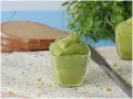 Deliziosa maionese di avocado in una ciotola di vetro, pronta per essere spalmata su fette di pane integrale.
