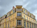 Żółta kamienica z zabytkowymi detalami, gdzie właśnie trwa wymiana okien w budynku wpisanym do gminnej ewidencji zabytków.
