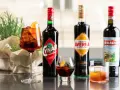 Verschiedene Campari-Sorten: Cynar, Averna und Braulio, serviert in Gläsern mit Eis und Orangenscheiben.