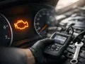 Motorkontrollleuchte leuchtet auf, ein Mechaniker prüft mit einem Diagnosegerät, ob der Katalysator defekt ist.