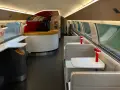 Interior of a TGV train carriage, ready for a journey from Amsterdam to Bordeaux. Booth seating and a bar area await passengers.