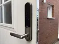 Yale Doorman, en smart lås som kan styras med Google Home, monterad på en vit dörr.